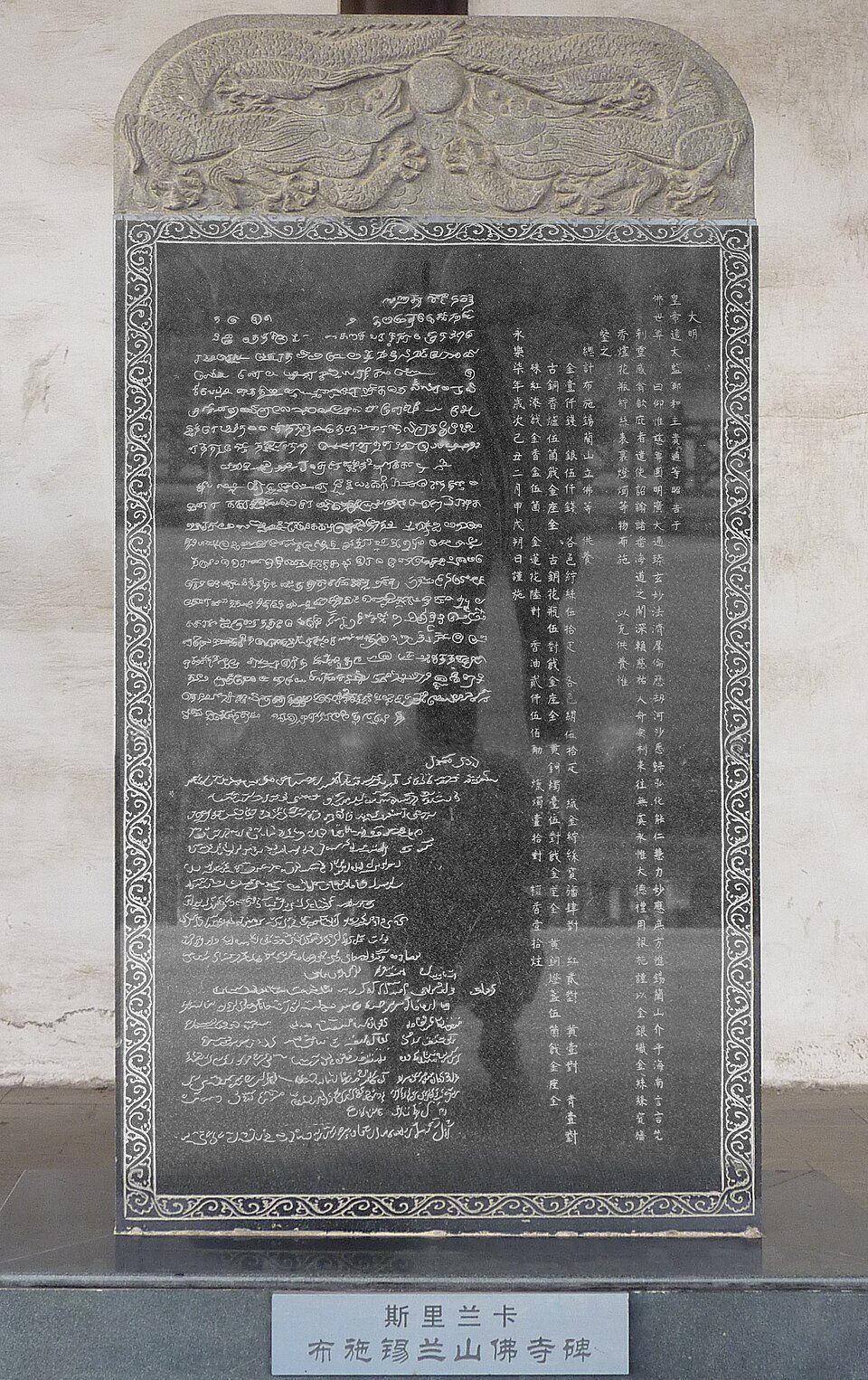 Trikalbės stelos kopija su kinų, tamilų ir persų užrašais